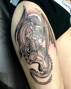 a woman with a dragon tattoo on her thigh