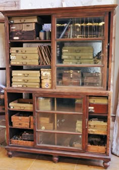 an old wooden bookcase filled with lots of books on top of a tiled floor