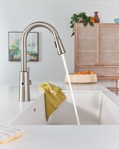 a kitchen faucet with a yellow cloth hanging from it's spout