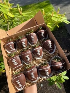 chocolate covered strawberries in a cardboard box with football decorations on them, sitting outside