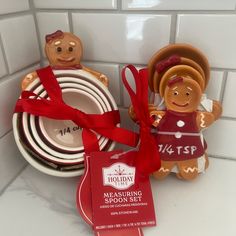 two gingerbread man figurines sitting next to each other in front of a white tile wall