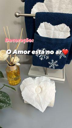 two towels hanging on a towel rack next to a vase with flowers