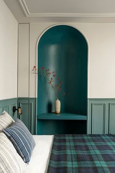 a bedroom with green walls and a bed in the foreground is a blue arch