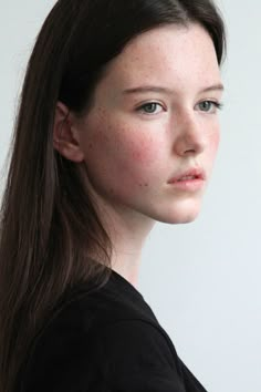 a woman with freckled hair is looking at the camera