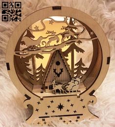 an ornament with a house in the woods on it's side and trees around it