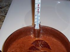 a pan with some food in it on a counter top next to a thermometer