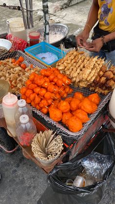 a man standing next to a table filled with different types of food on it's sides