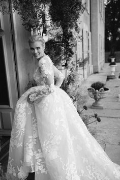 a black and white photo of a woman in a wedding dress posing for the camera