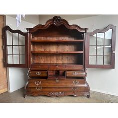 an old fashioned wooden dresser with glass doors