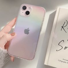 a person holding an iphone case next to a book