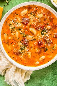 a white bowl filled with soup and garnished with parmesan cheese