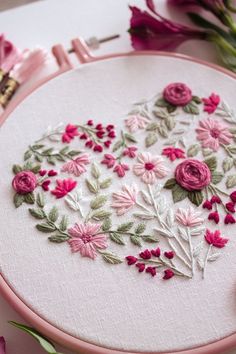 a close up of a embroidery on a table with flowers