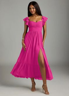 a woman in a long pink dress posing for the camera with her legs slited