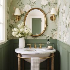 a white sink sitting under a mirror in a bathroom next to a wall mounted faucet