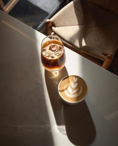 two cups of coffee sitting on top of a white table