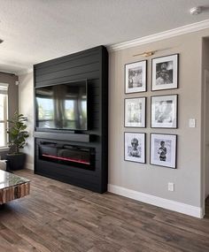 a living room with wood flooring and pictures on the wall