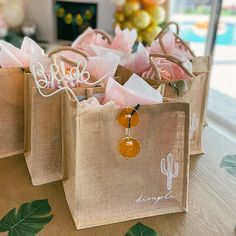 three bags with personalized items on them sitting on a table in front of a window