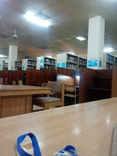 an empty library with several bookshelves and blue ribbon on the table in front of it