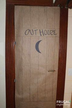 a door with the words out house written on it and a crescent moon painted on it