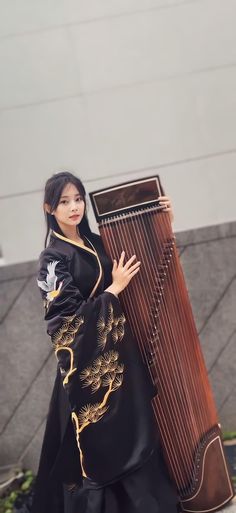 a woman is holding a large musical instrument