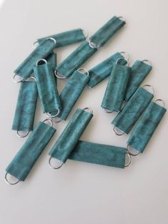 several pieces of turquoise colored paper with silver rings