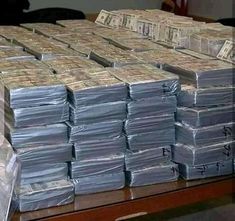 stacks of money sitting on top of a wooden table