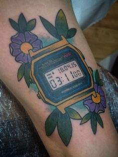 a tattoo with a clock and flowers on it