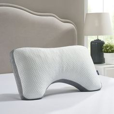 a white pillow sitting on top of a bed