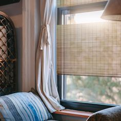 a window seat in front of a window with bamboo blinds