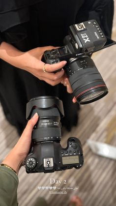 two people holding camera equipment in their hands