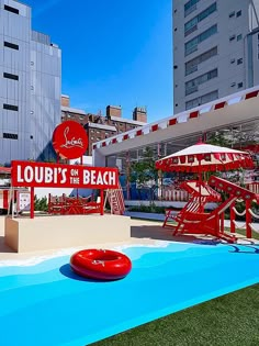 a pool with a life preserver and water slide in front of a large building