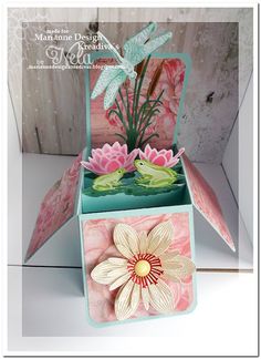 an open card box with flowers inside and on the inside, in front of a wooden background