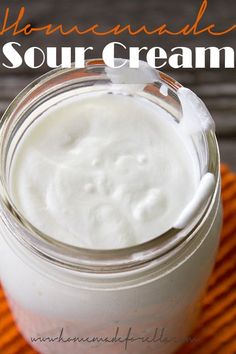 homemade sour cream in a glass jar on an orange towel