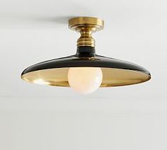 a black and gold ceiling light hanging from the ceiling in a room with white walls