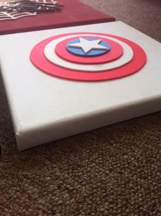 the captain's shield painted on top of a canvas is laying on the floor