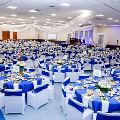 a banquet hall set up with blue and white linens