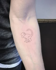 a man's arm with a small monkey tattoo on the left side of his arm