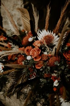 an arrangement of flowers and feathers on display