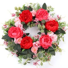 a wreath with red and pink flowers on it