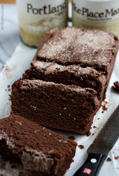 a stack of chocolate donuts sitting on top of a cooling rack