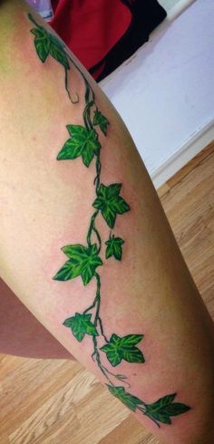 a woman's leg with green leaves on it