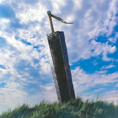 a tall metal pole sitting on top of a lush green field under a blue cloudy sky