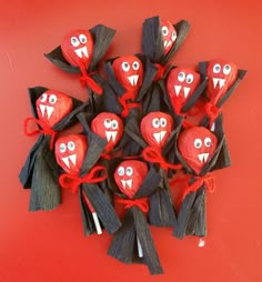 a group of red and black candy bats with eyes, mouths and teeth on them