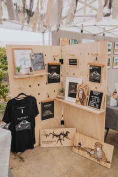 there are some pictures and t - shirts on display in the tent with other items