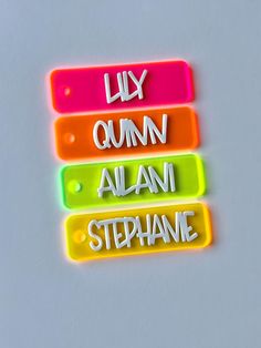 three neon colored name tags with the words live, cumn, alum, and stephanie