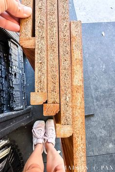 a person standing next to a wooden bench