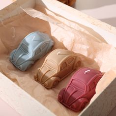 three small toy cars are in a box