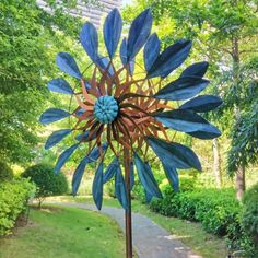 a metal sunflower sculpture in the middle of a park