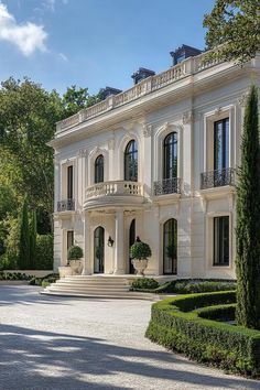 a large white house surrounded by trees and bushes