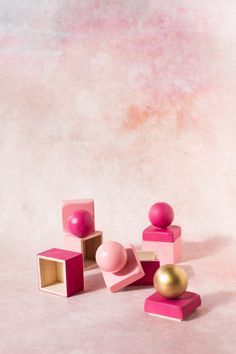 some pink and gold objects on a white surface with a light colored background that looks like something out of space